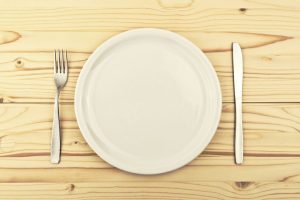 White plate on a table with a fork and knife